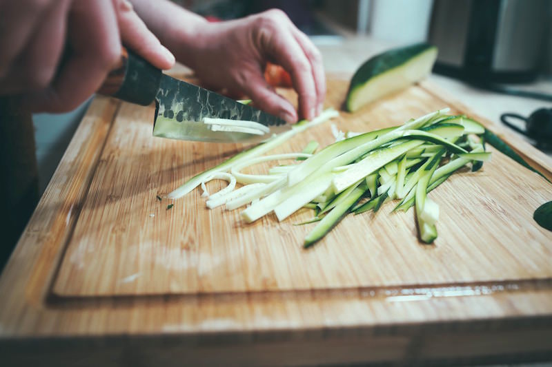Chopping zucchini on a wood cutting board
