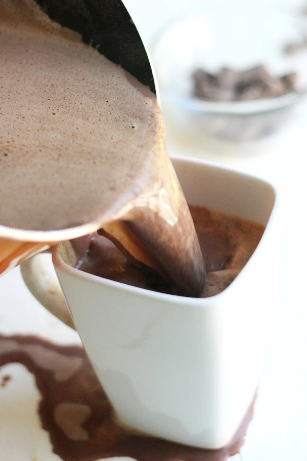 Pouring hot chocolate into a mug from a saucepan