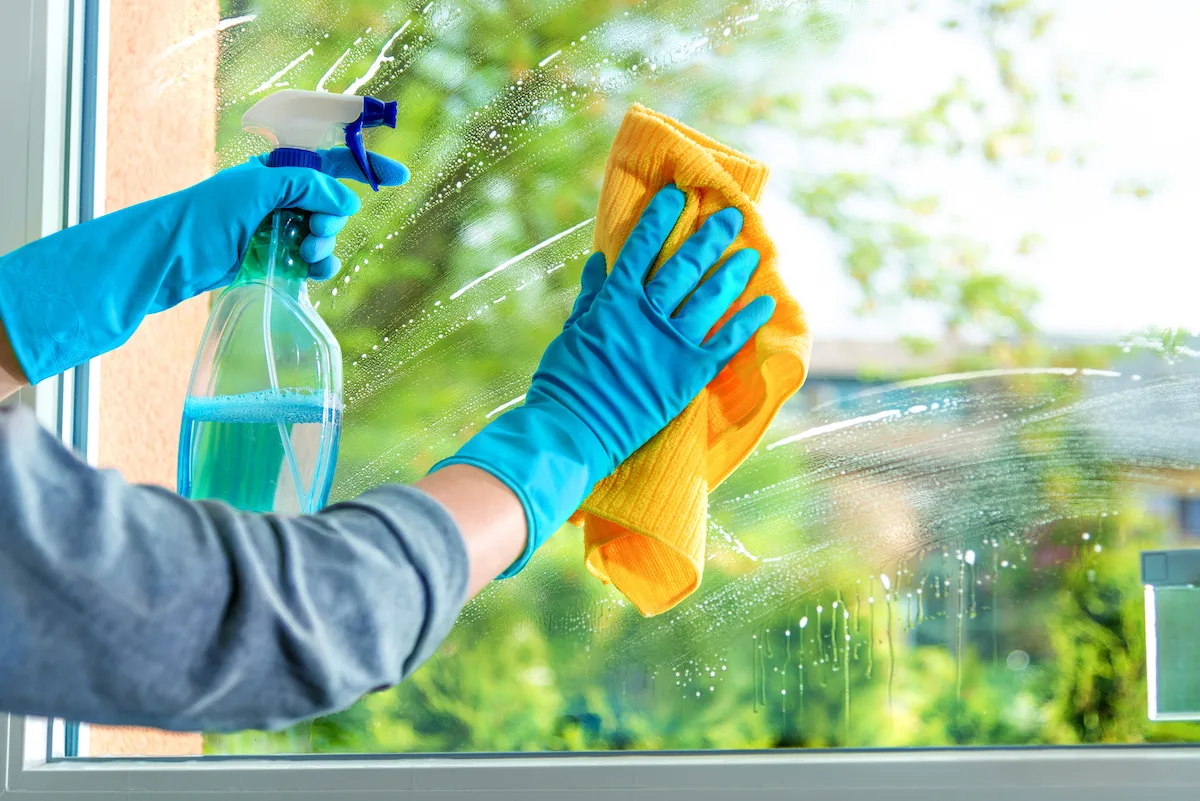 https://diycandy.b-cdn.net/wp-content/uploads/2020/03/Woman-wearing-gloves-sprayinga-window-with-window-cleaner-and-then-wiping-it-off.jpeg.webp