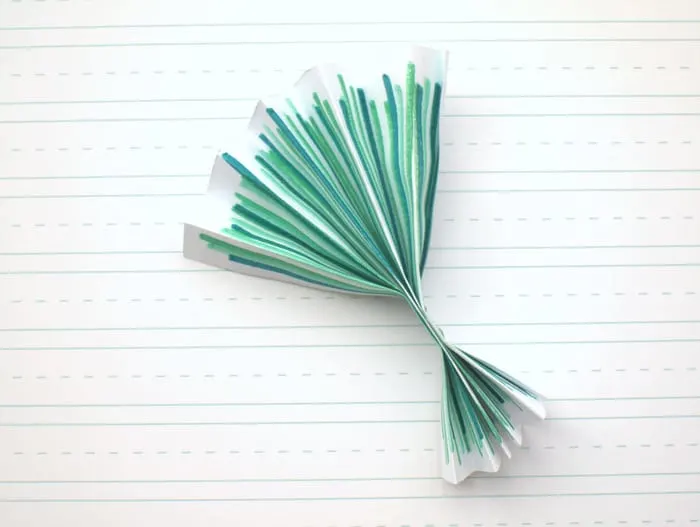 Paper with green marker folded into the base of a bouquet