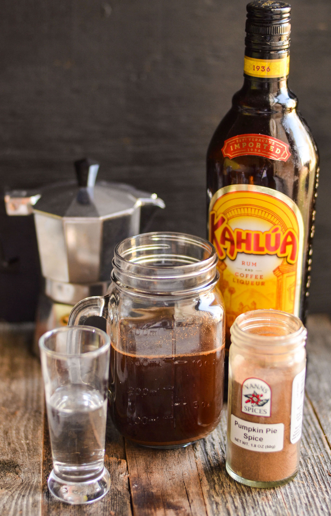 Coffee in a mason jar, bottle of Kahlua, pumpkin pie spice, shot of vodka