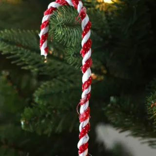 DIY candy cane ornament hanging on a tree branch