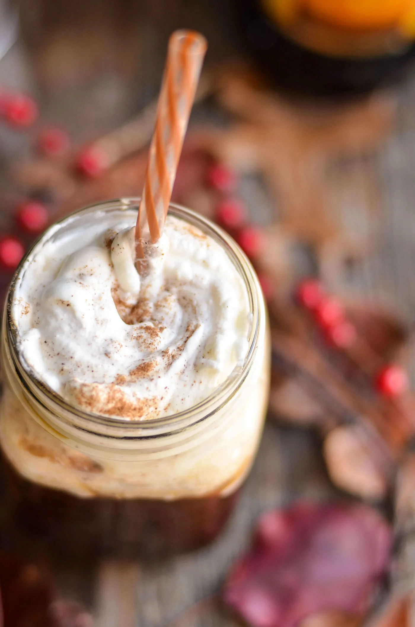 pumpkin coffee cocktail in a mason jar with whipped cream on top