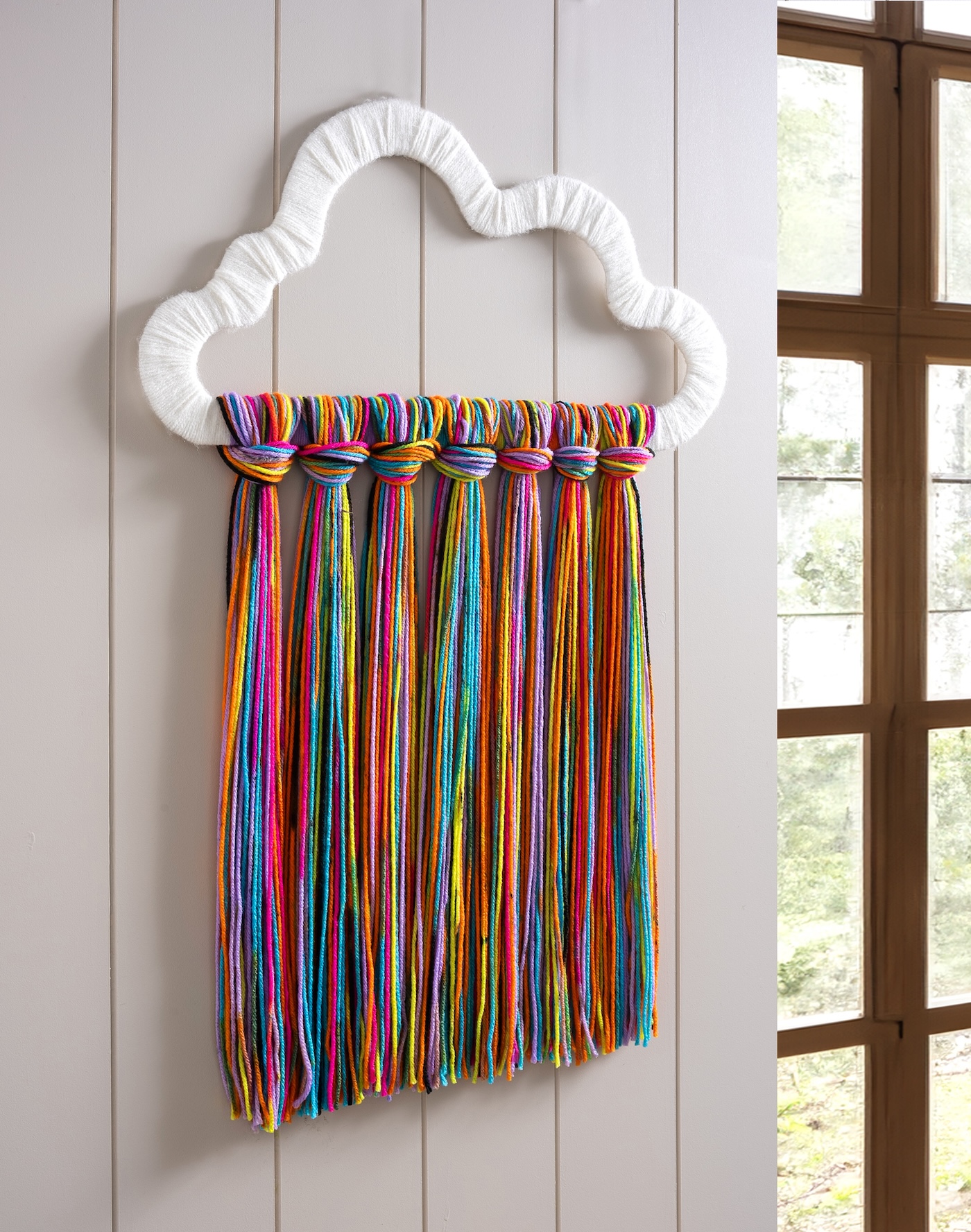 DIY yarn wall art shaped like a rainbow