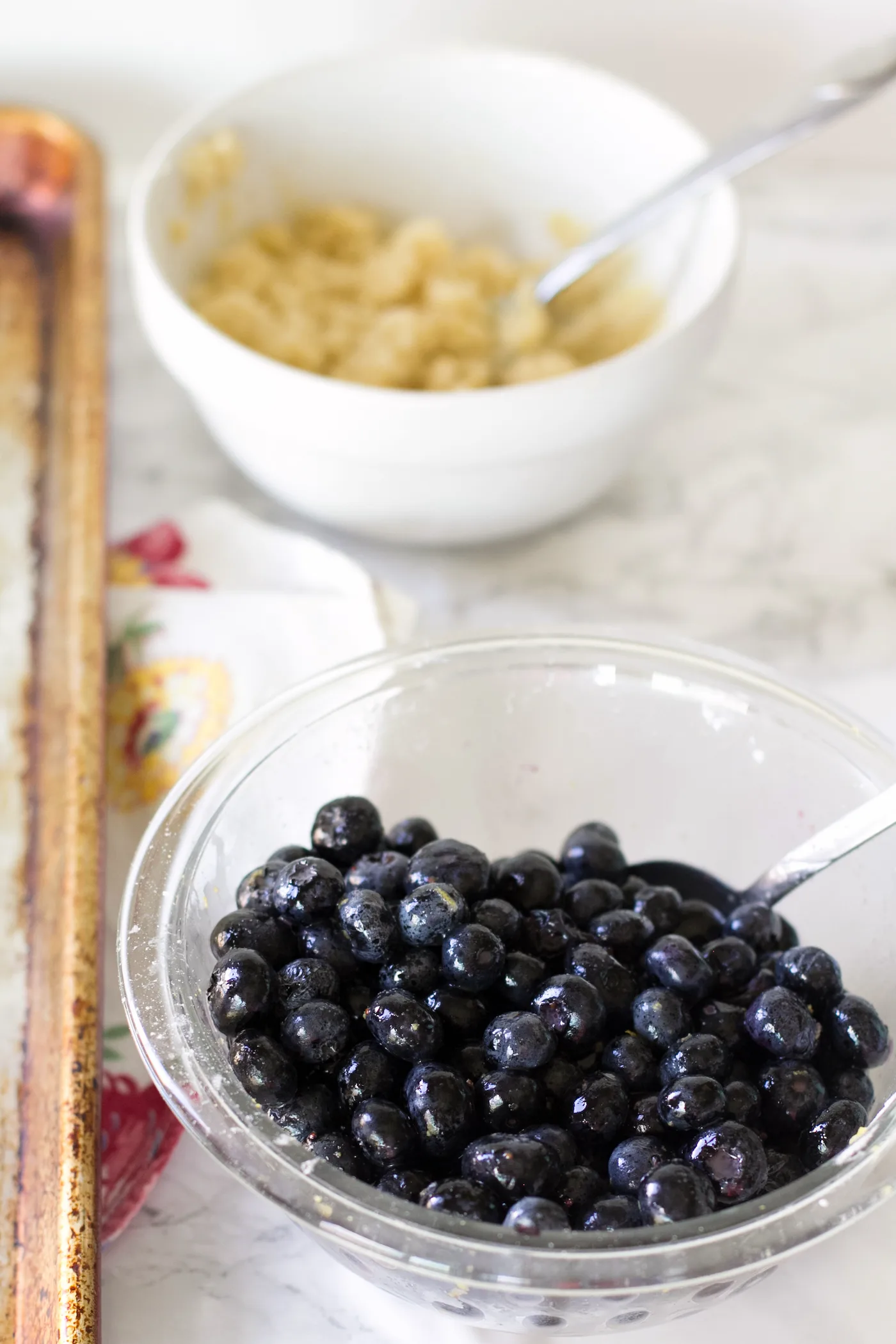 Blueberries in a glass bowl mixed with lemon juice and lemon zest