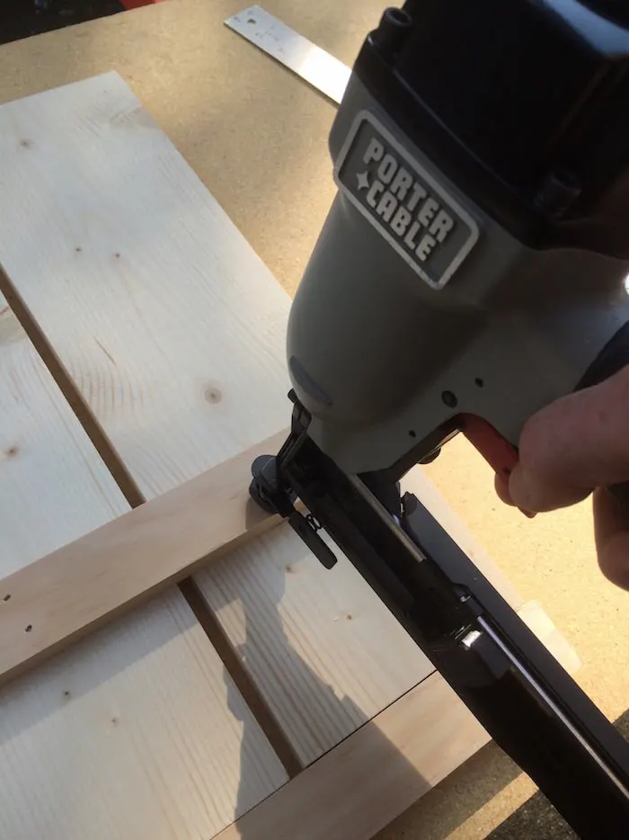 Staple gun attaching two pieces of wood