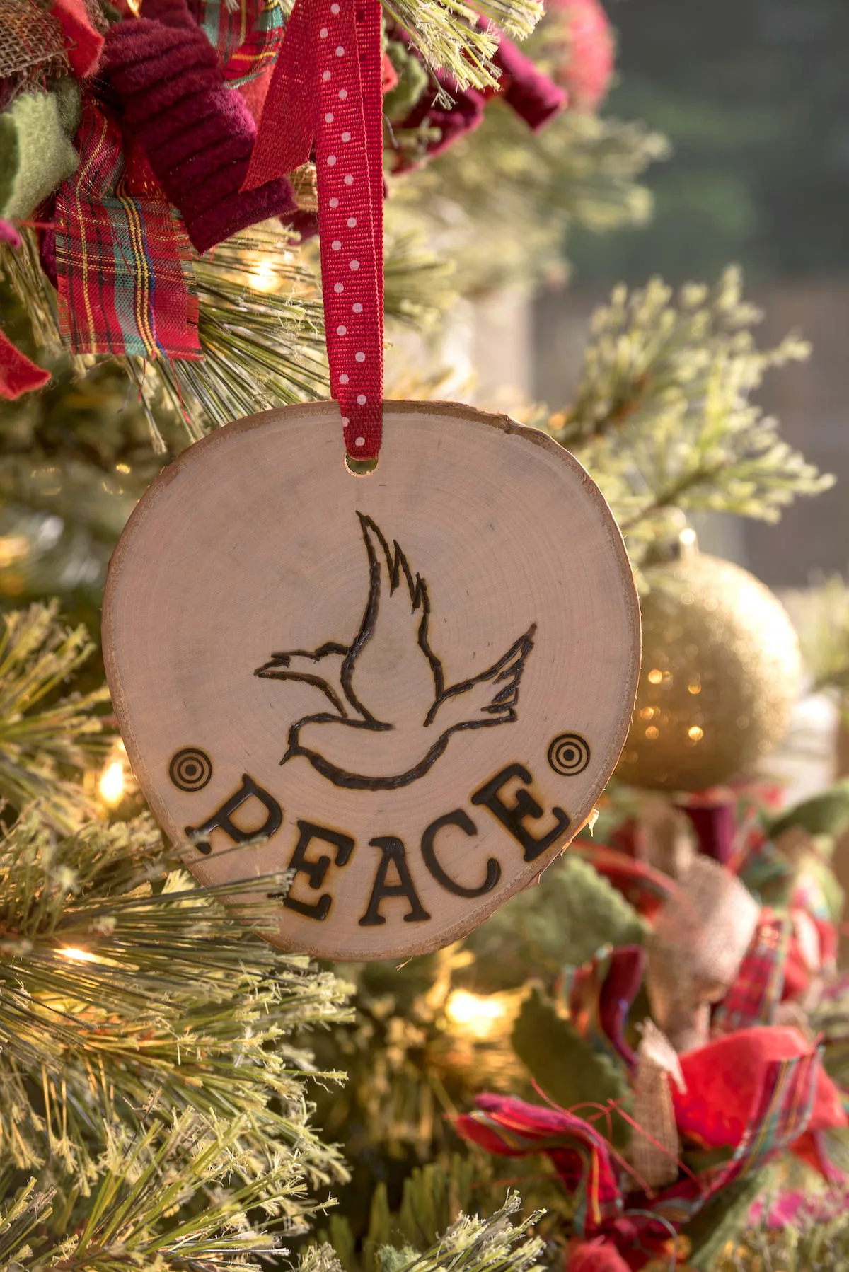 Peace wood slice ornament on a Christmas tree