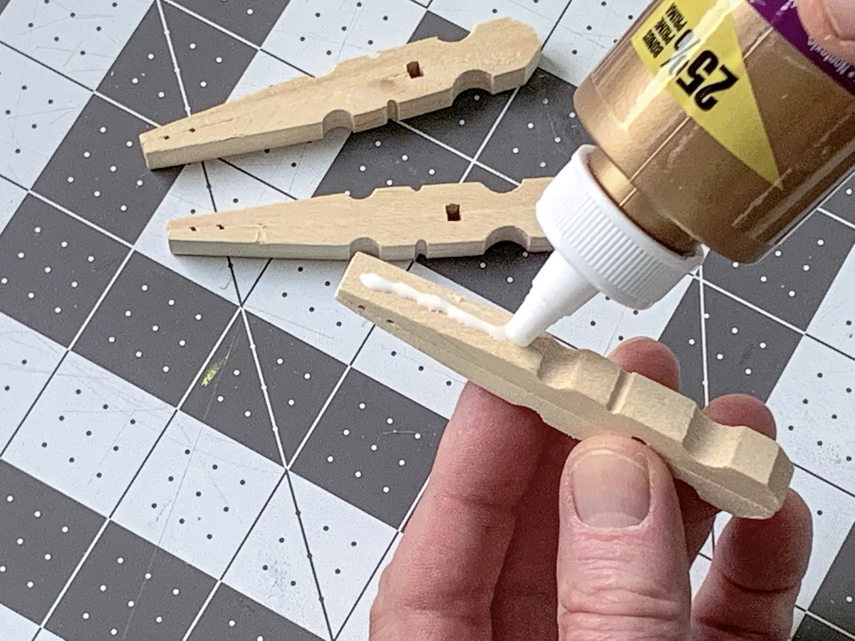 Adding glue to one side of a clothespin
