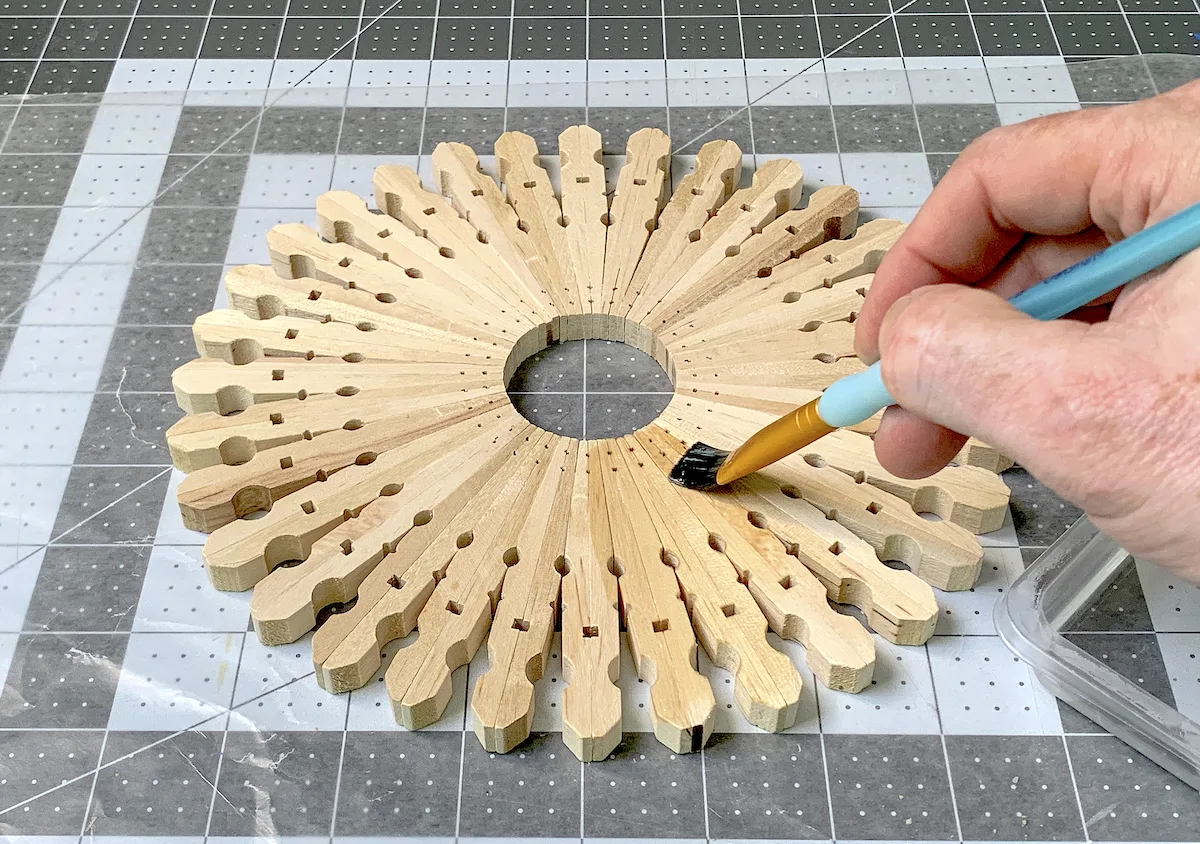 Brushing mineral oil onto a clothespin trivet