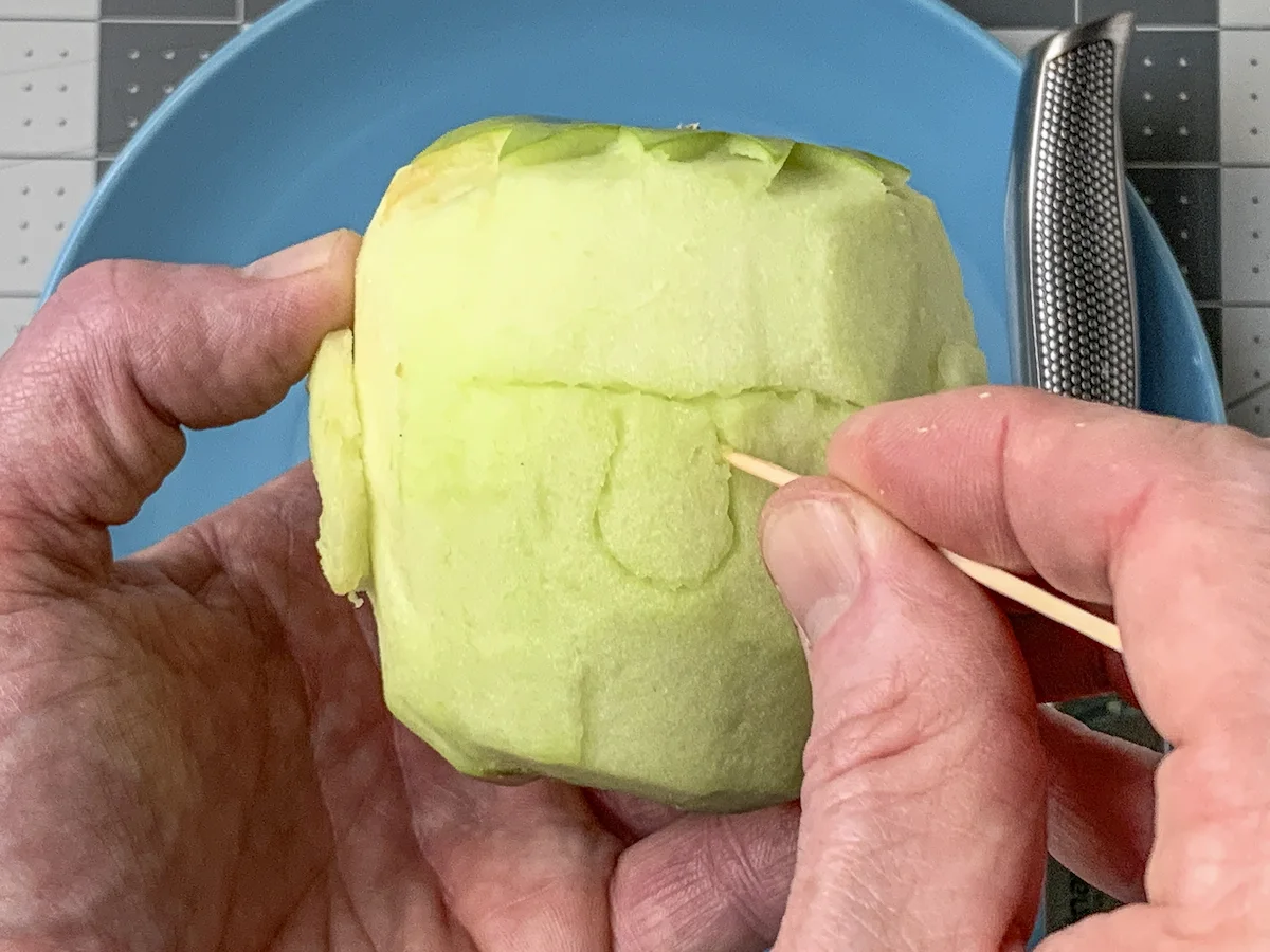 Drawing a nose on the apple with a toothpick