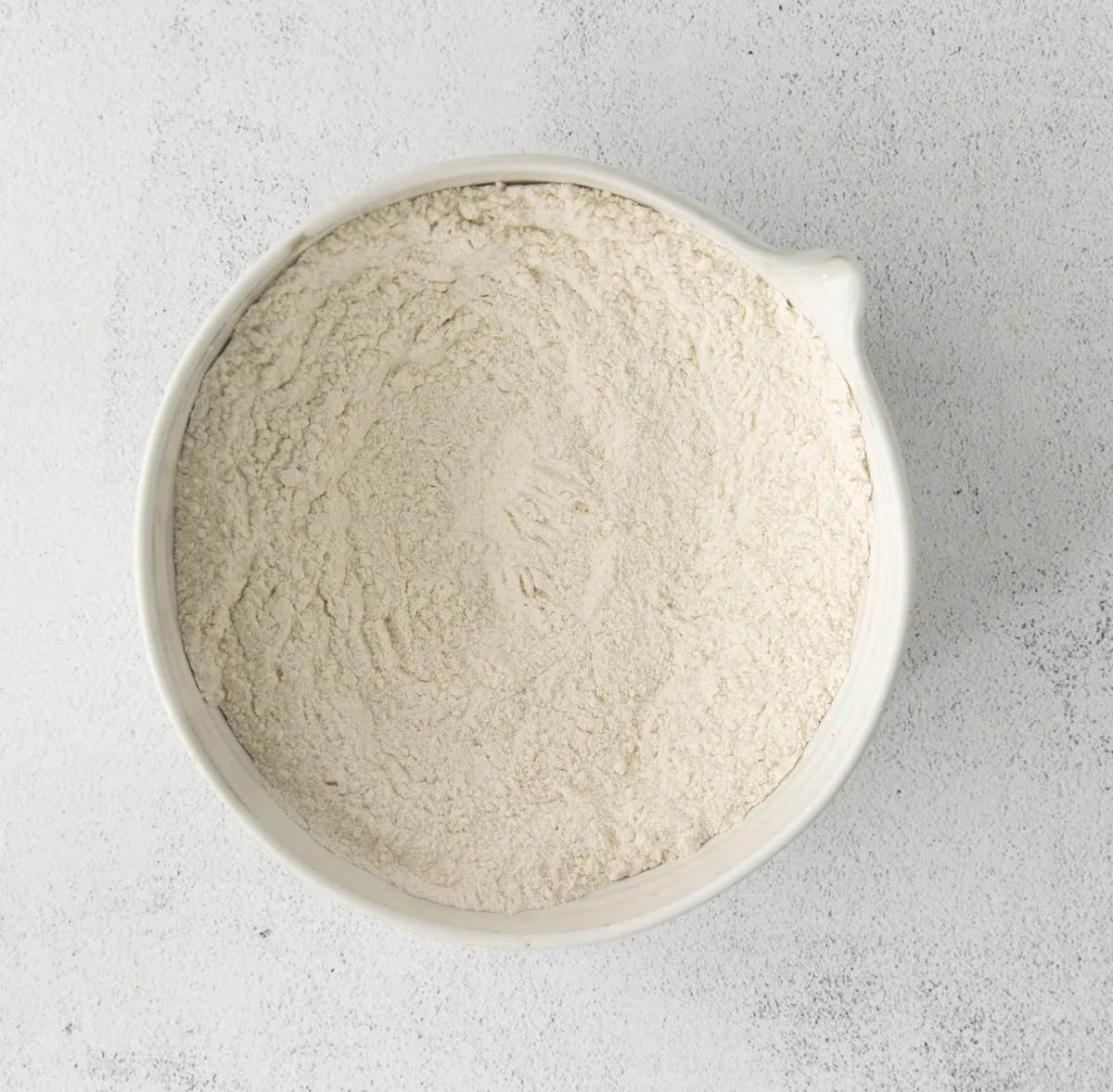 Flour, sugar, and baking powder whisked together in a bowl