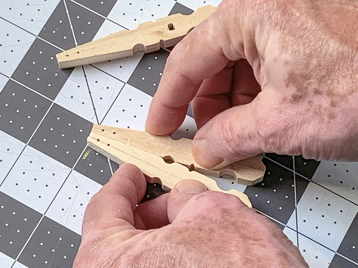Pressing two clothespins with glue on them together