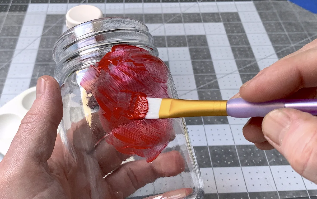 Painting a glass jar with red multisurface paint