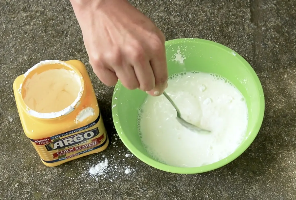 Water added to cornstarch and being stirred in a bowl