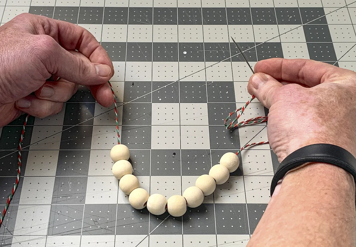 Ten wood beads strung onto baker's twine with a needle