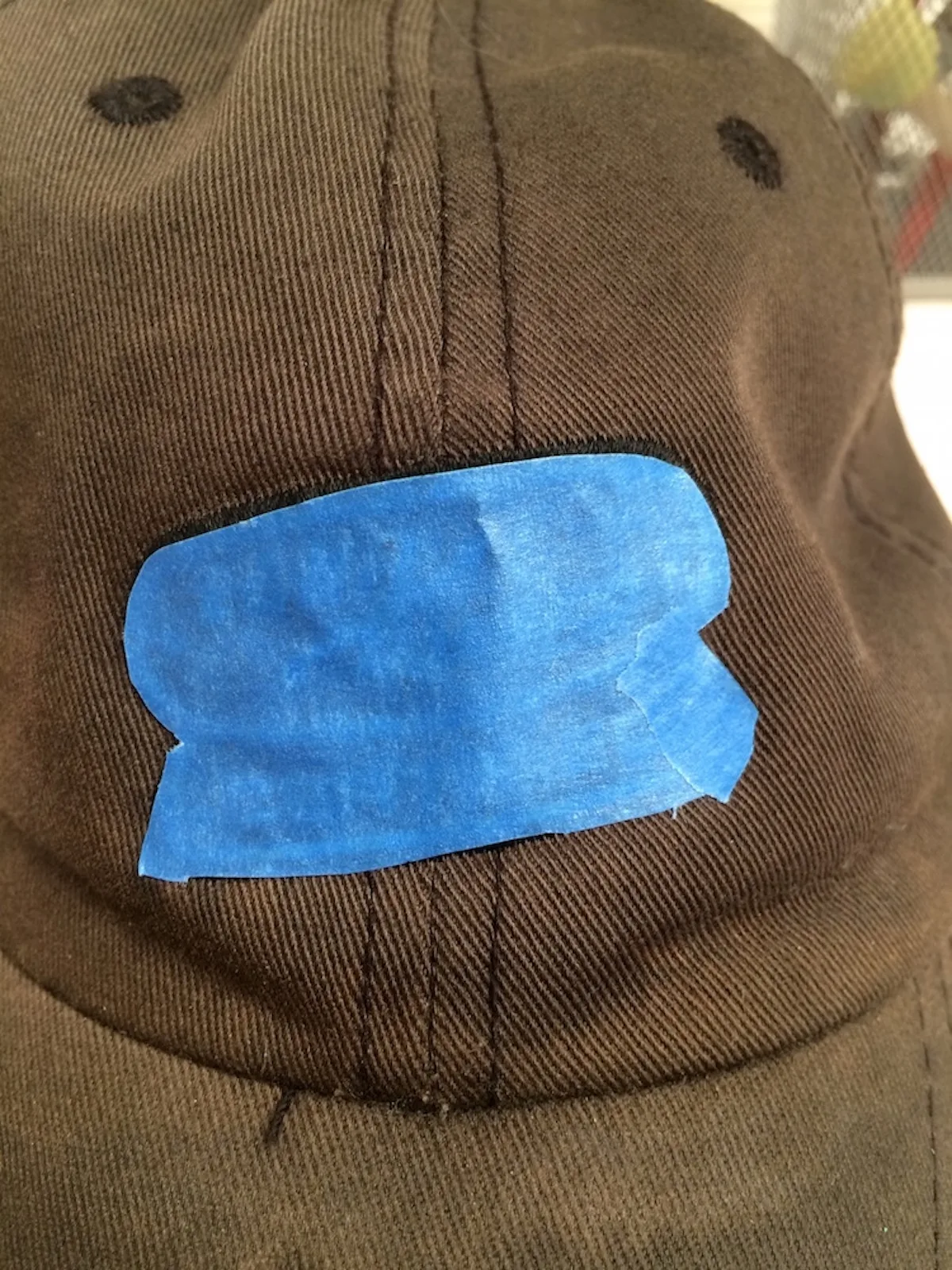 faded baseball hat with the logo covered