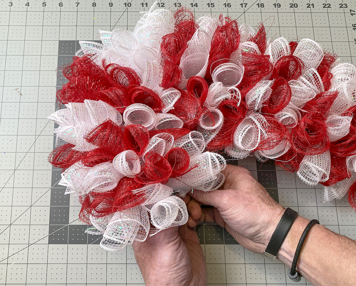 Adding the last piece of deco mesh to the candy cane wreath