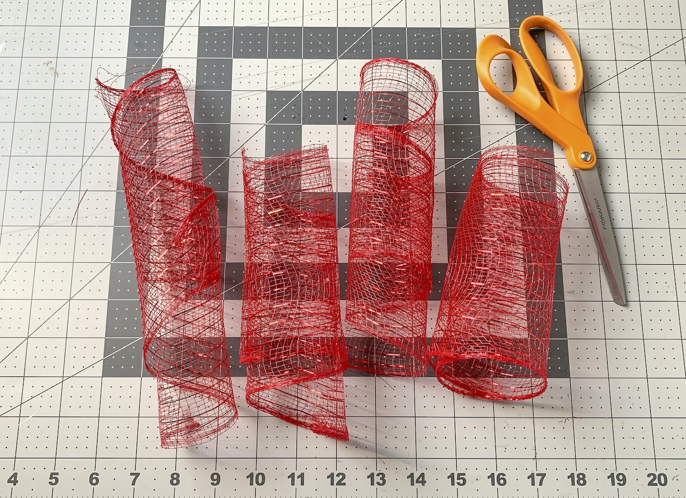 Four lengths of red deco mesh and a pair of scissors