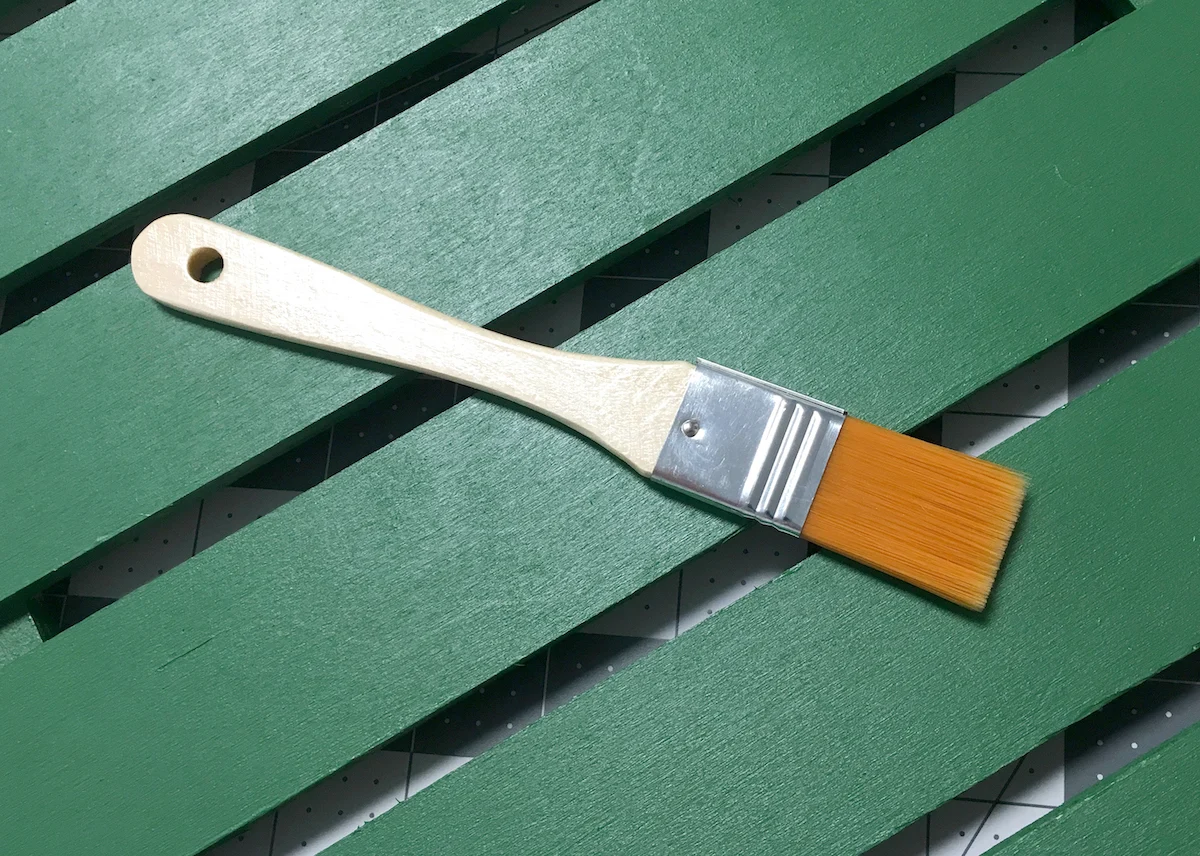 Paint brush on top of a painted wood pallet