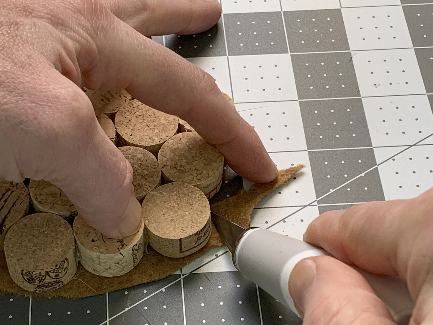 Trimming felt from around the wine corks with a craft knife