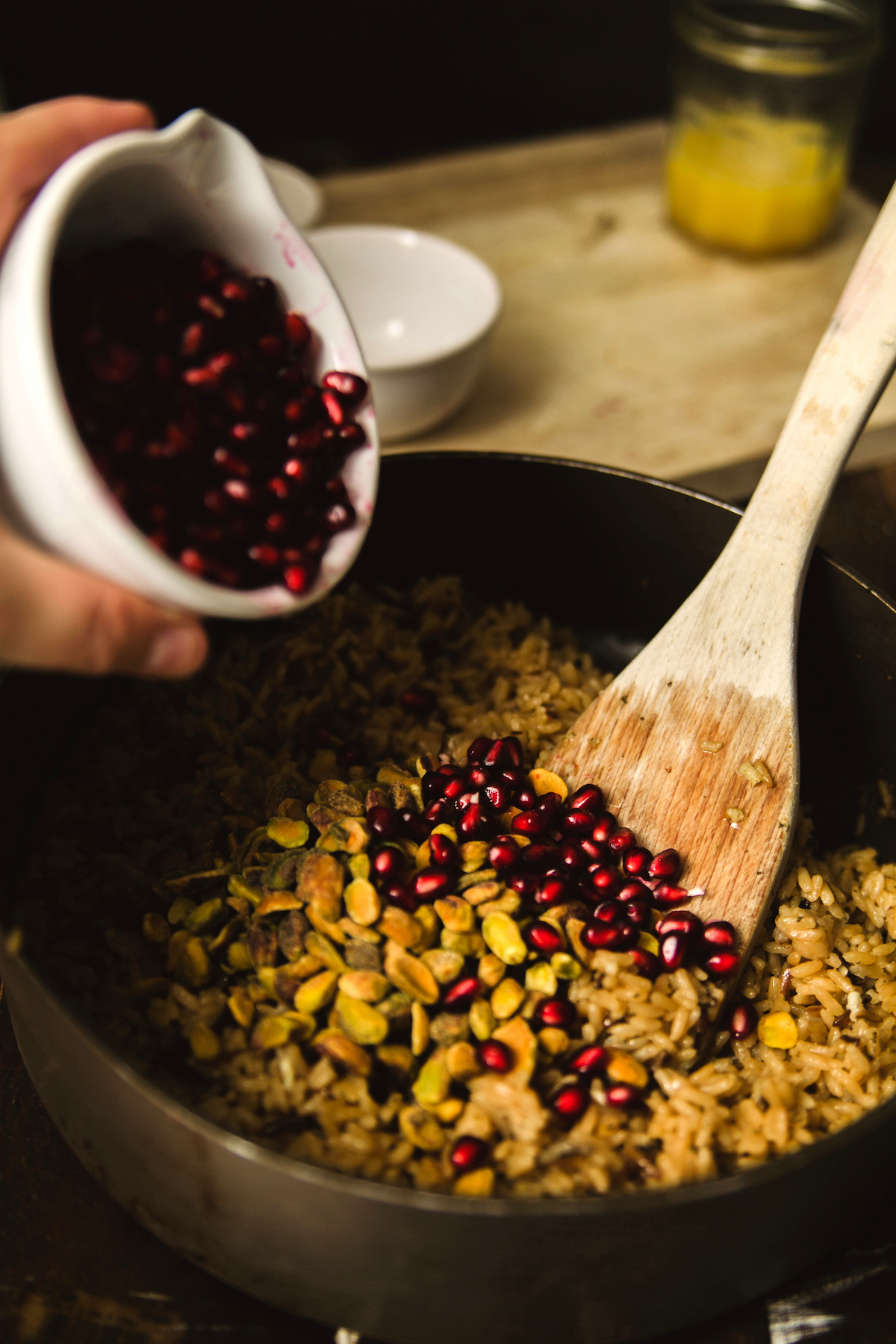 Pomegranate seeds being poured into the rice
