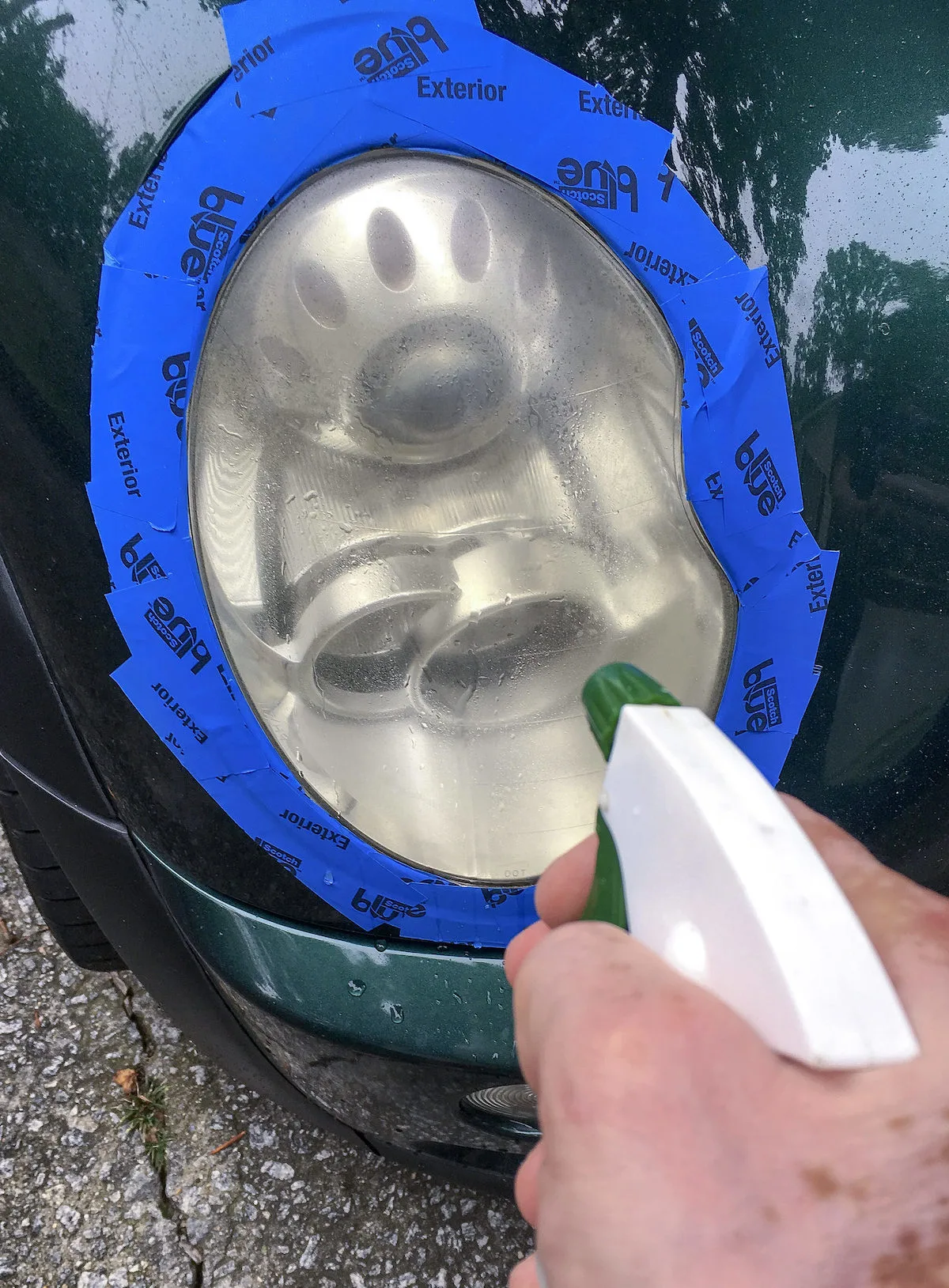 Spraying-water-on-a-taped-off-headlight-with-a-spray-bottle