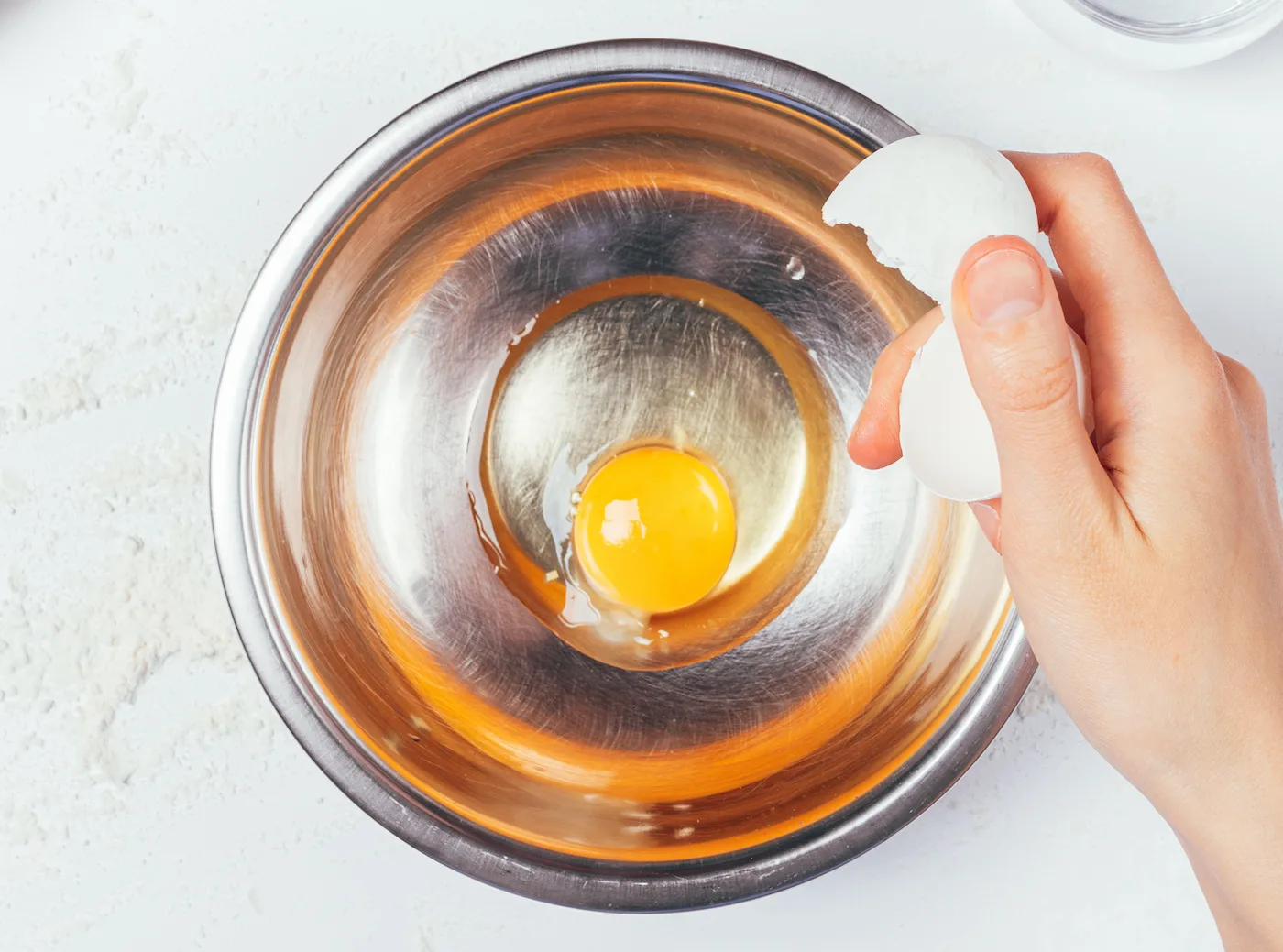 Hand-breaking-an-egg-into-a-bowl
