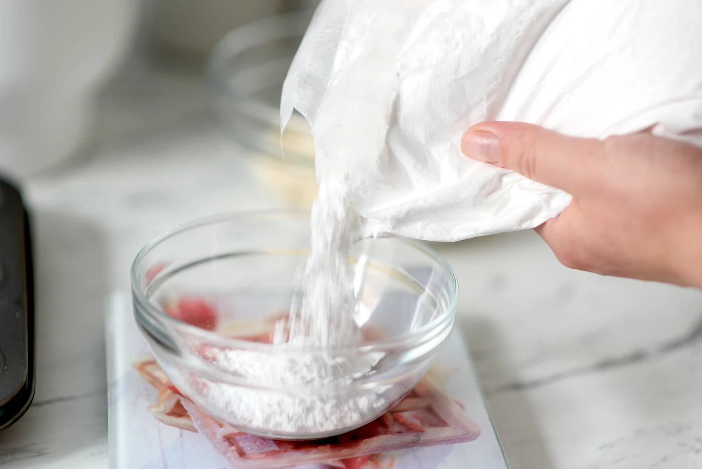 Pouring confectioner's sugar into a bowl