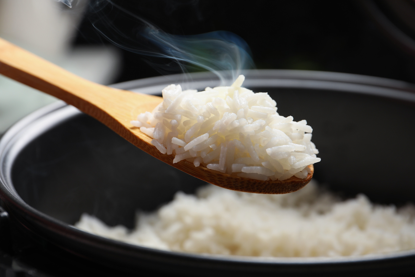 Cooked-rice-in-a-wooden-spoon-above-a-pot