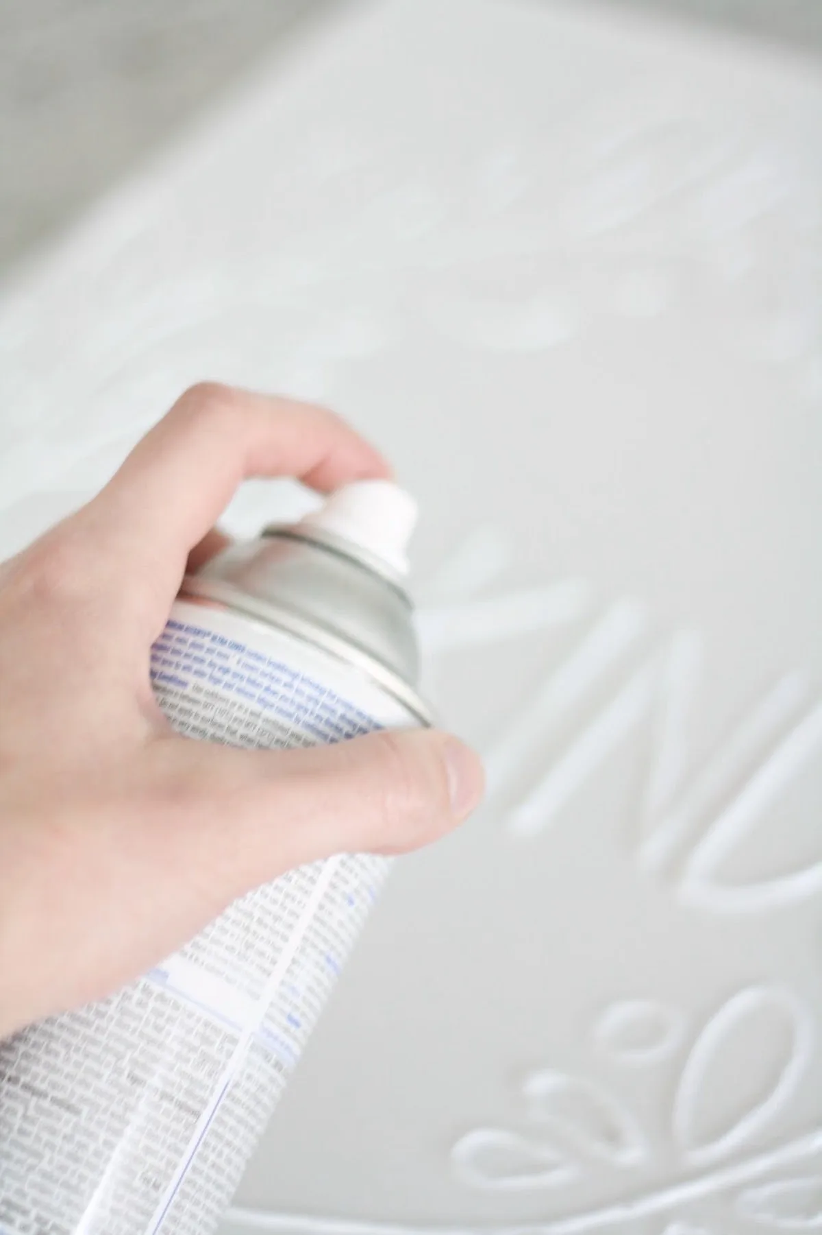 Spray painting the canvas with white spray paint