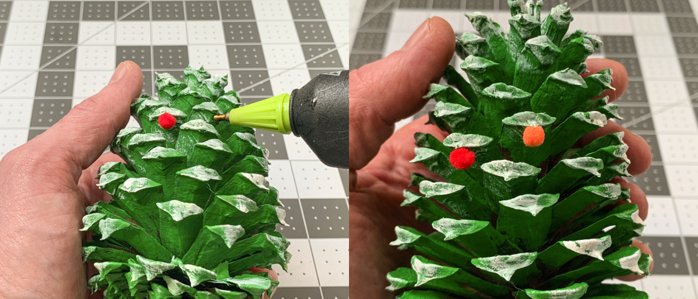 Gluing pom poms to the pine cone as ornaments