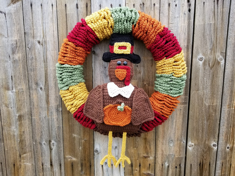 crochet thanksgiving wreath with turkey holding a pumpkin