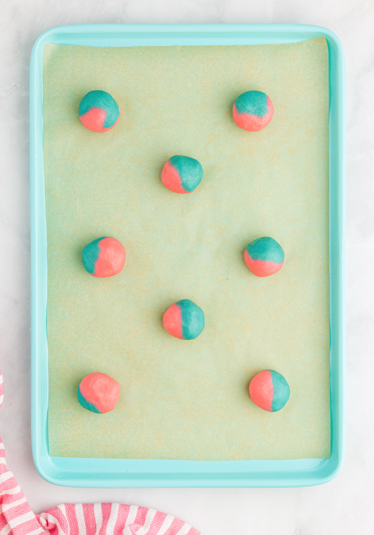 Cotton candy cookie balls placed on a baking sheet