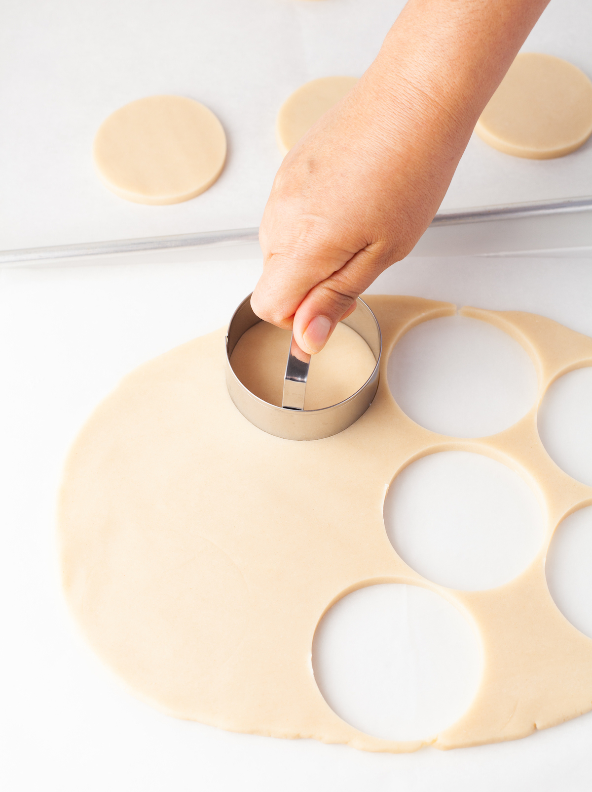 Hand cutting circles out of dough