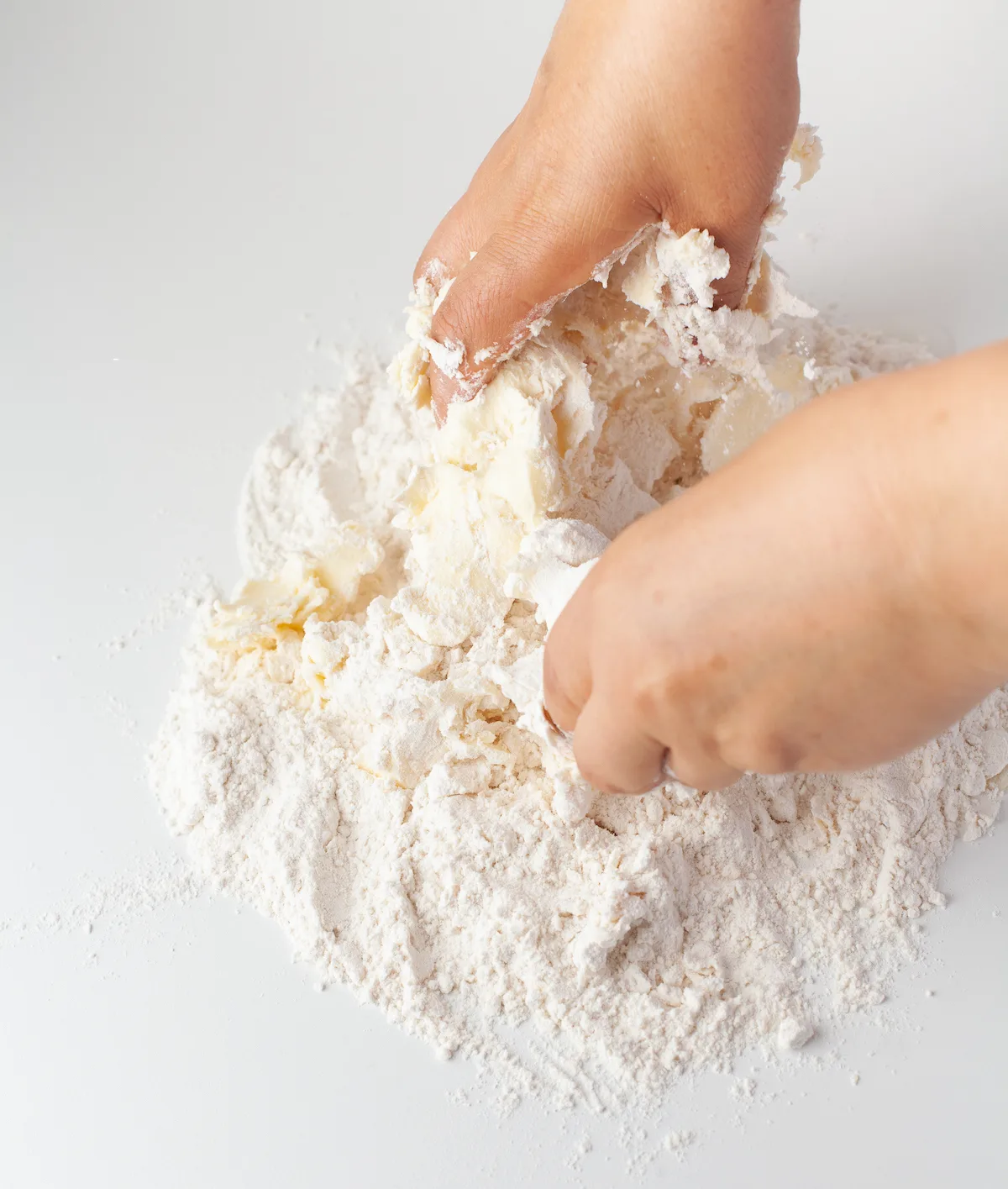 Hands kneading the flour, butter, and salt together