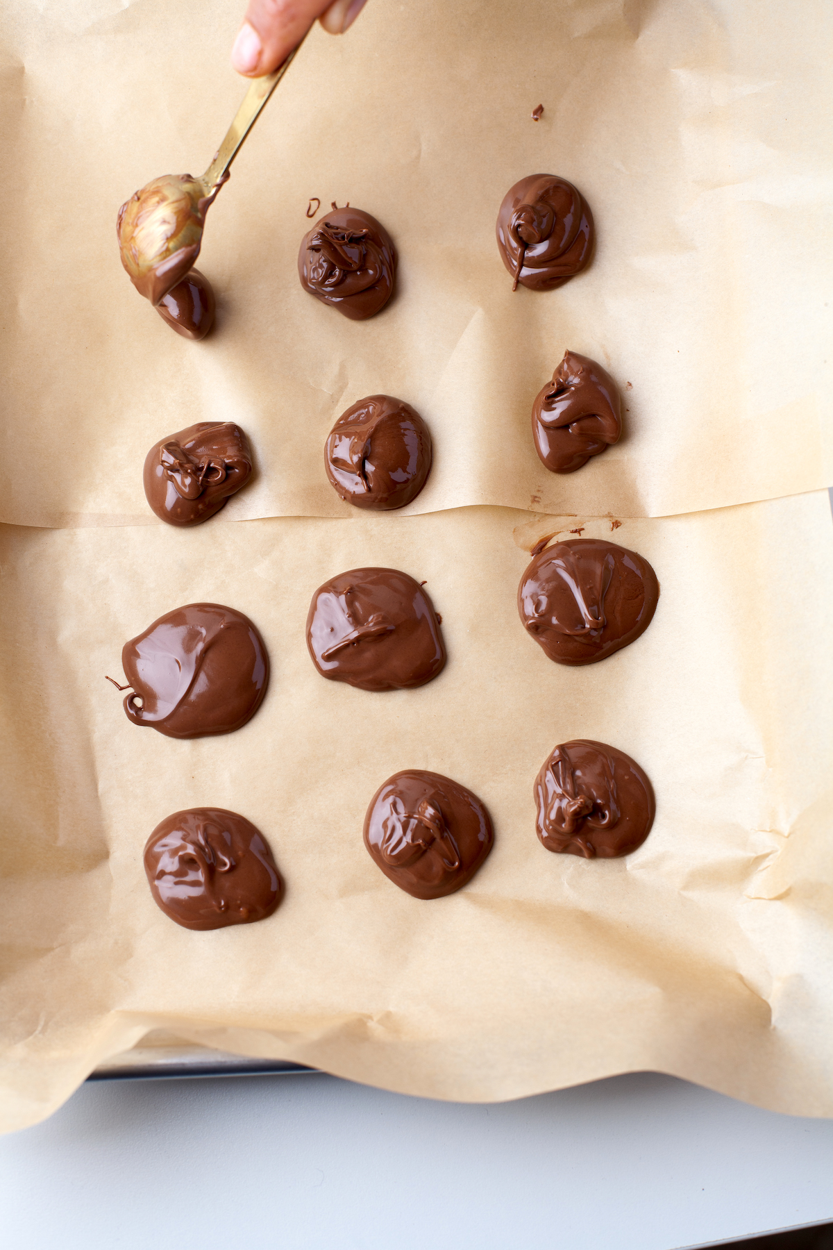 Placing teaspoons of Nutella on a parchment paper covered tray
