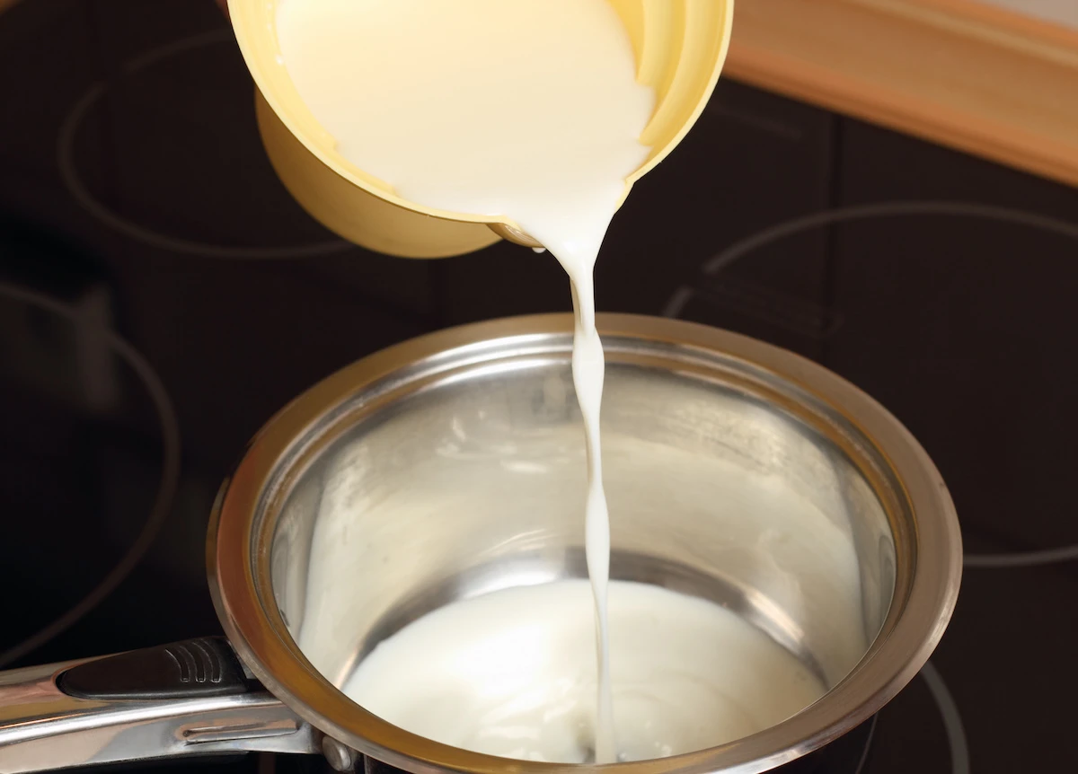 Adding-milk-and-cream-to-a-saucepan