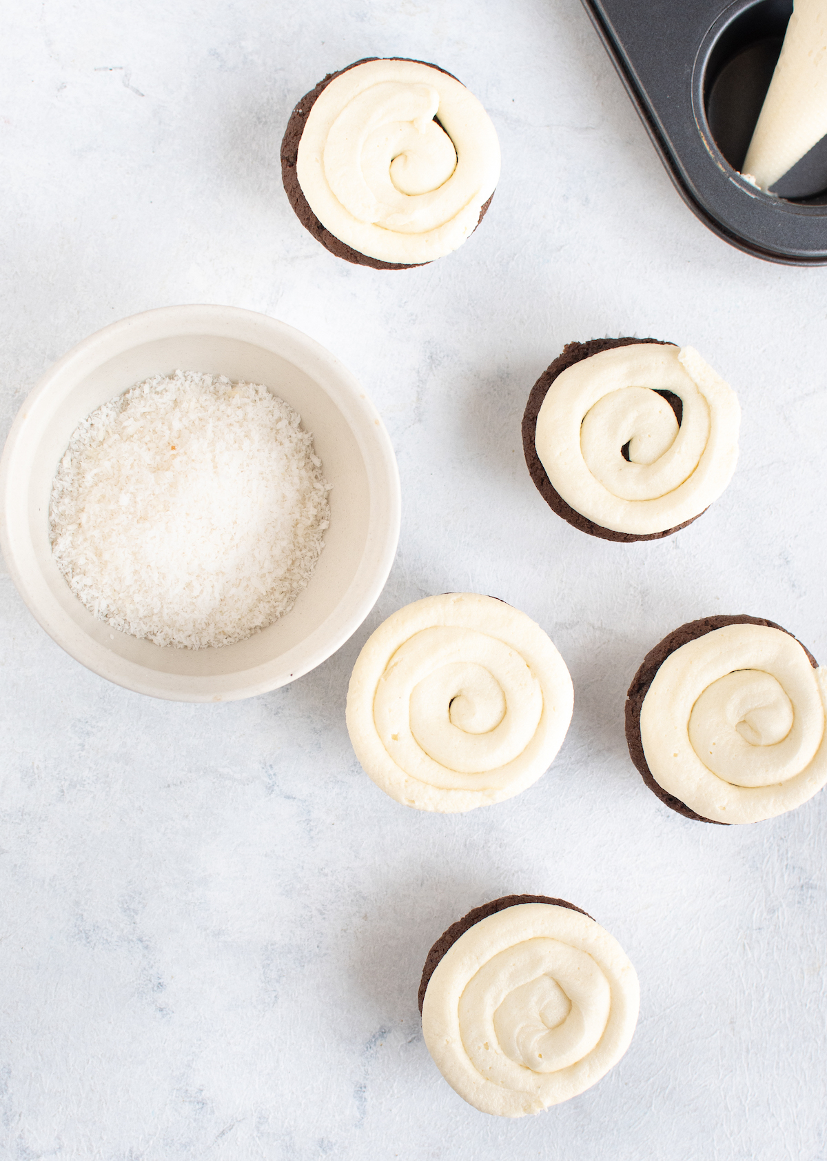 Chocolate cupcakes piped with white frosting