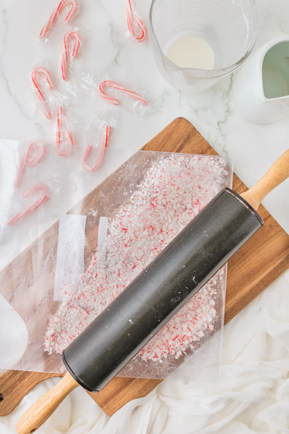 Crushing candy canes in a plastic bag with a rolling pin