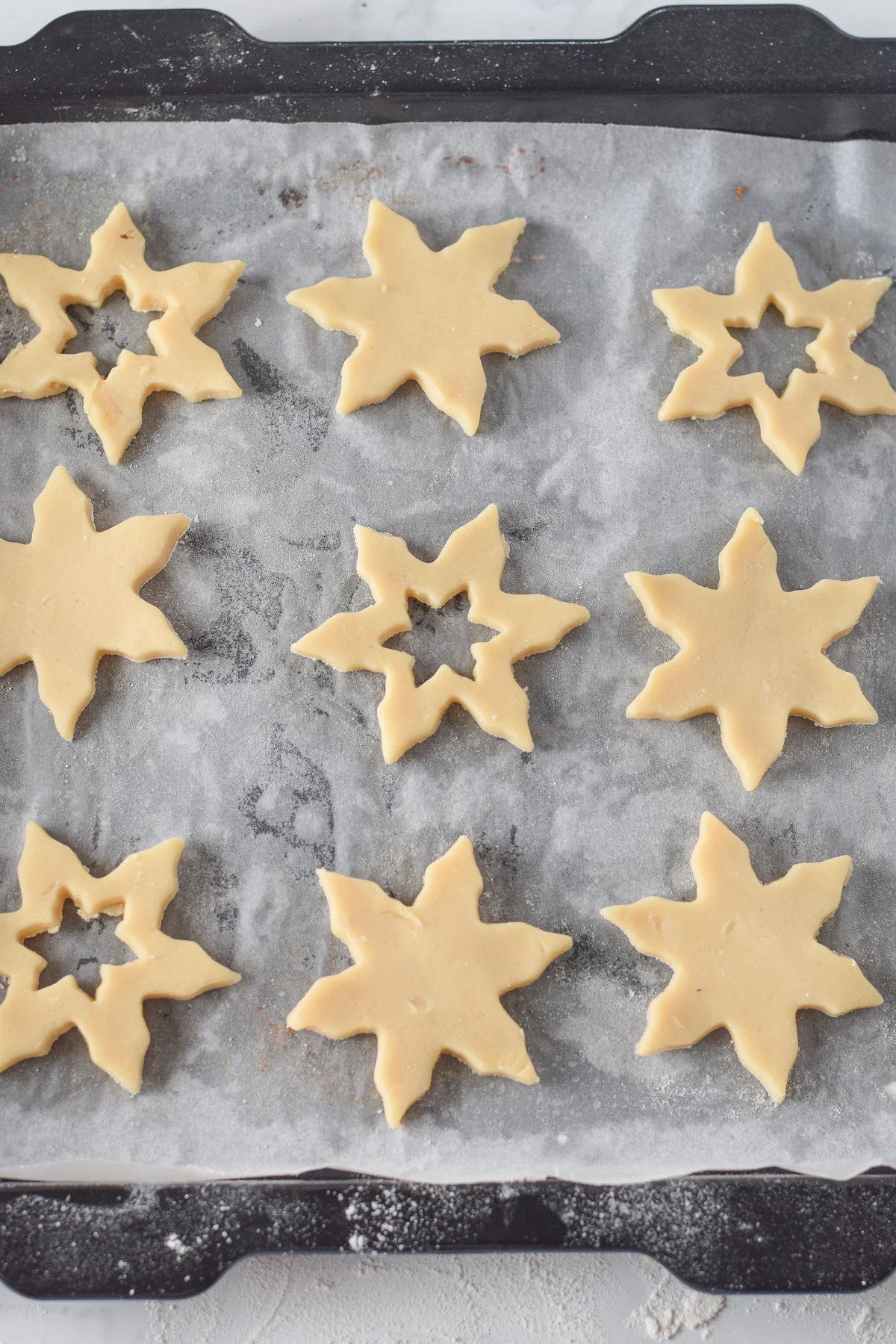 Cut out star cookies on a baking sheet