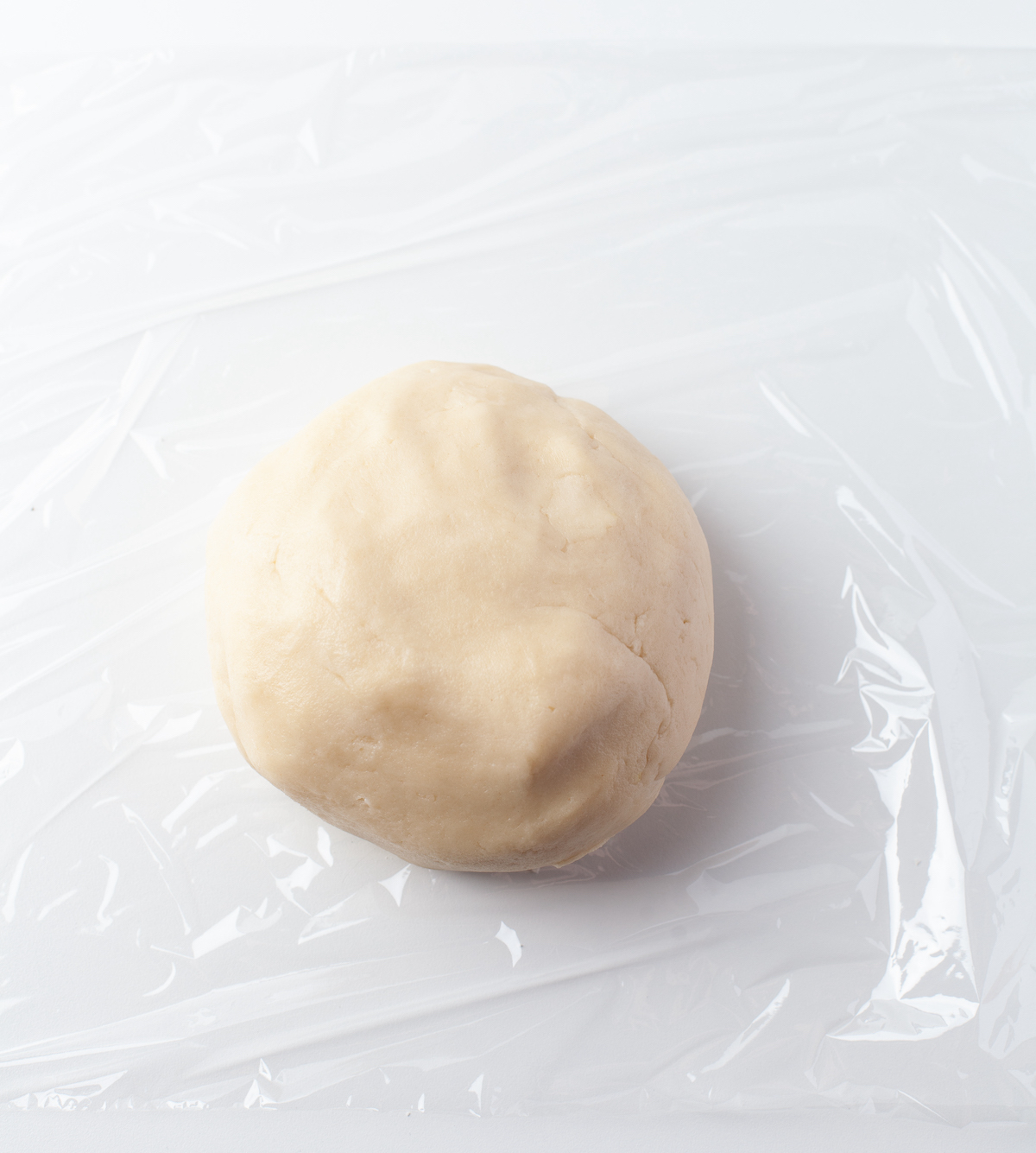 Dough being wrapped in plastic wrap to go into the fridge