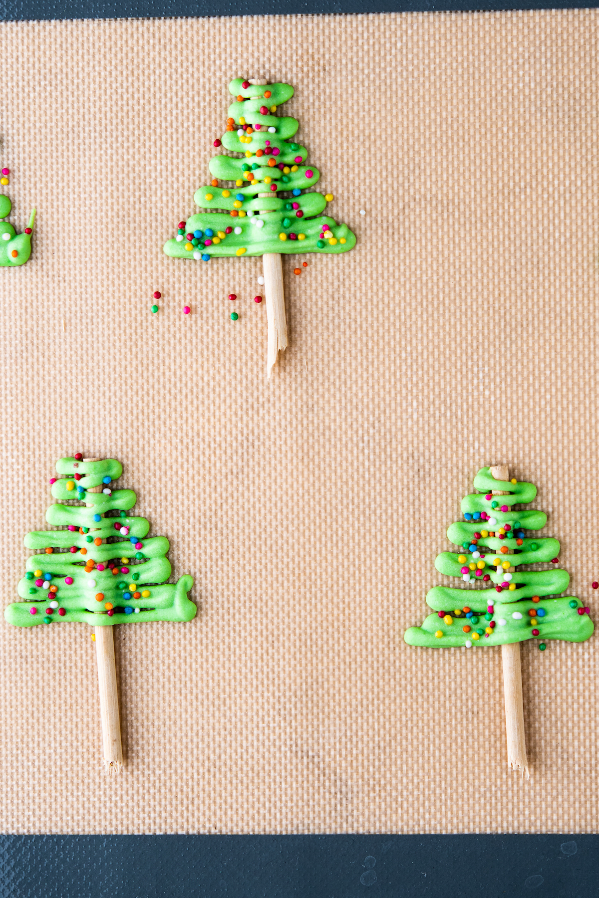 Green colored chocolate drizzled over pretzels to make trees