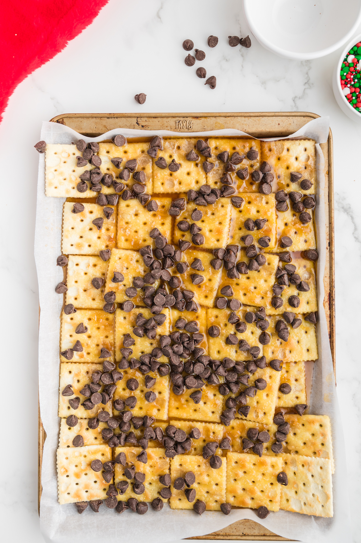 Milk chocolate chips spread over the saltines