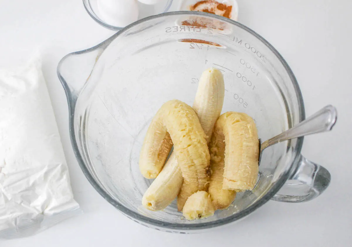 Peeled bananas placed into a clear glass bowl