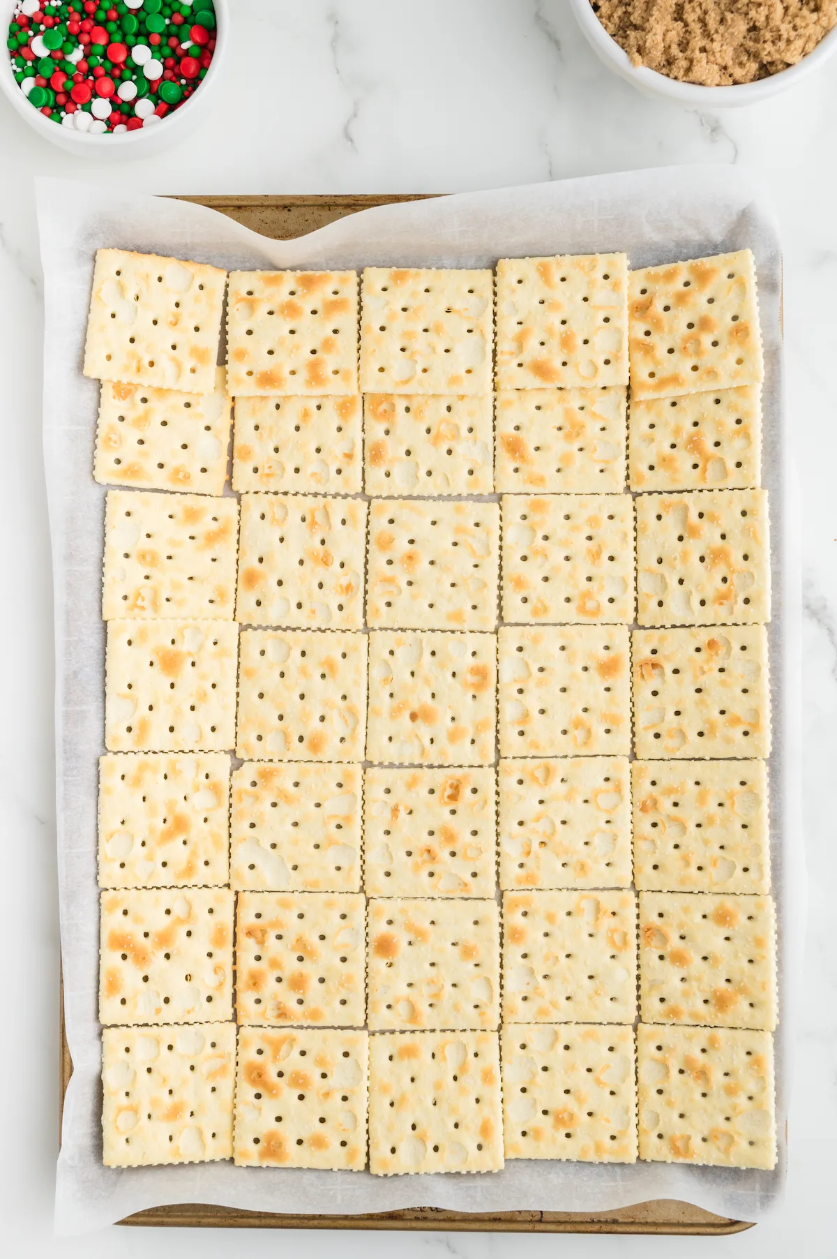 Saltine crackers laid in a single layer on a baking sheet