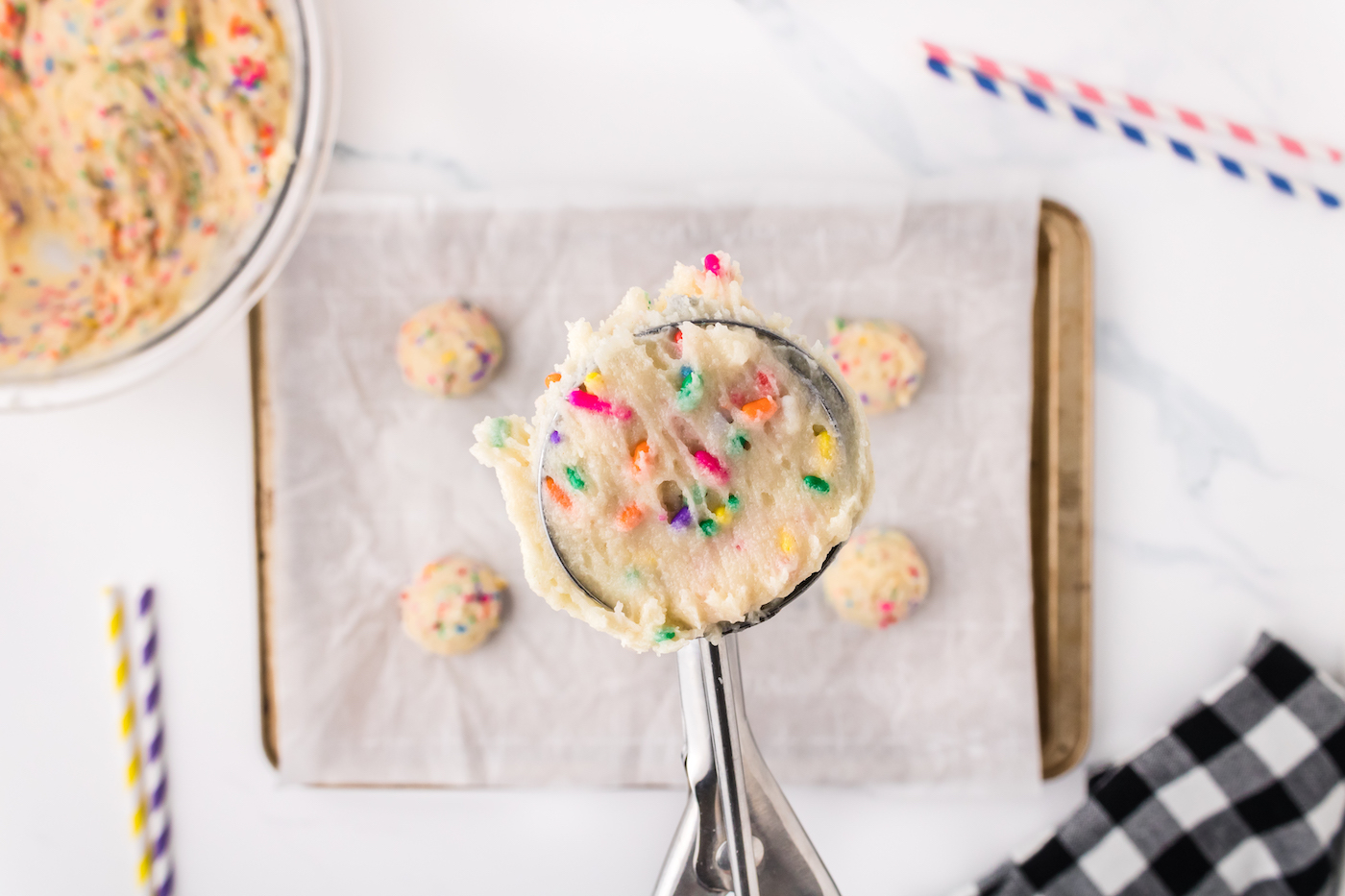 Scooping the funfetti cookie dough onto the cookie sheet