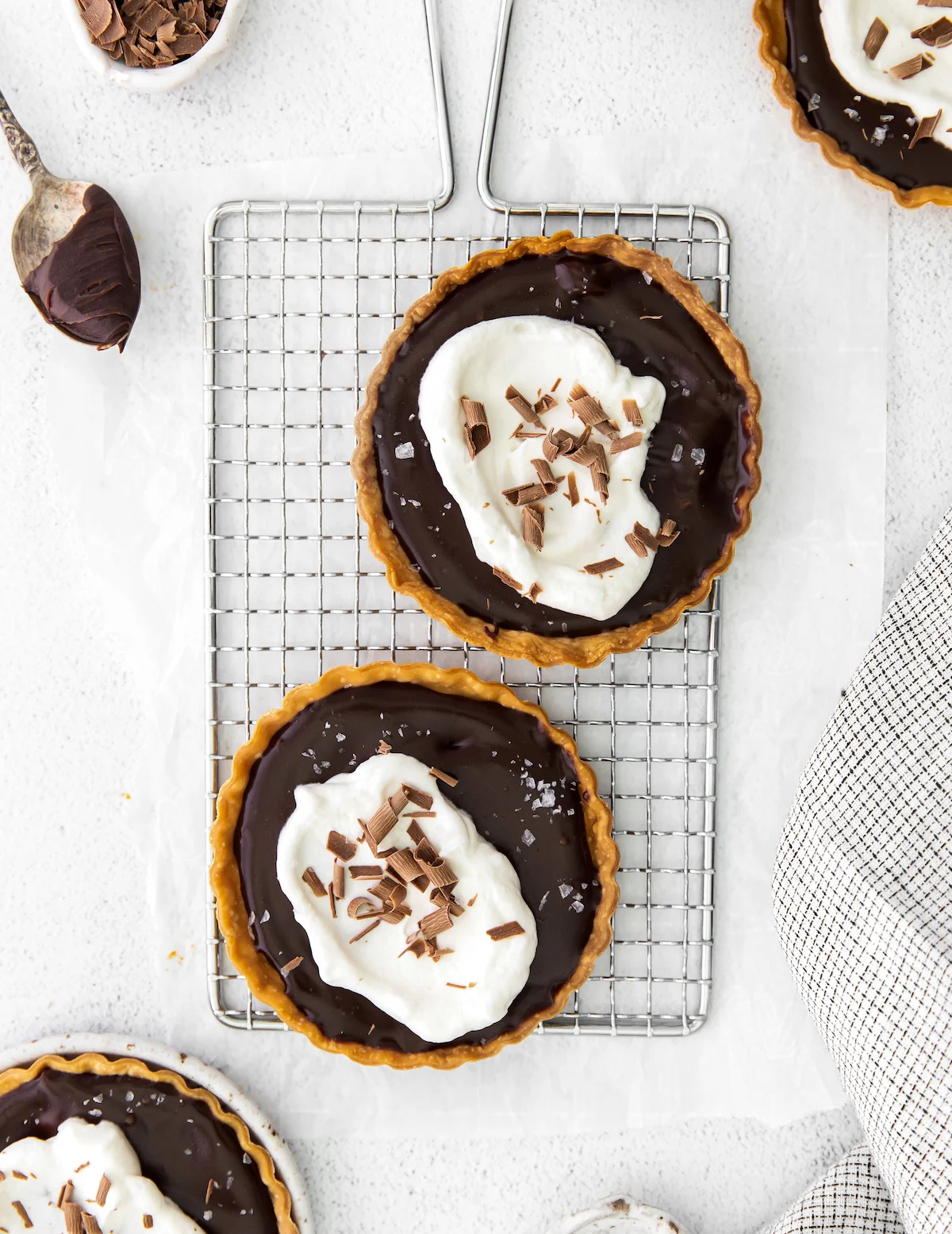 Tarts with whipped cream added and chocolate shavings
