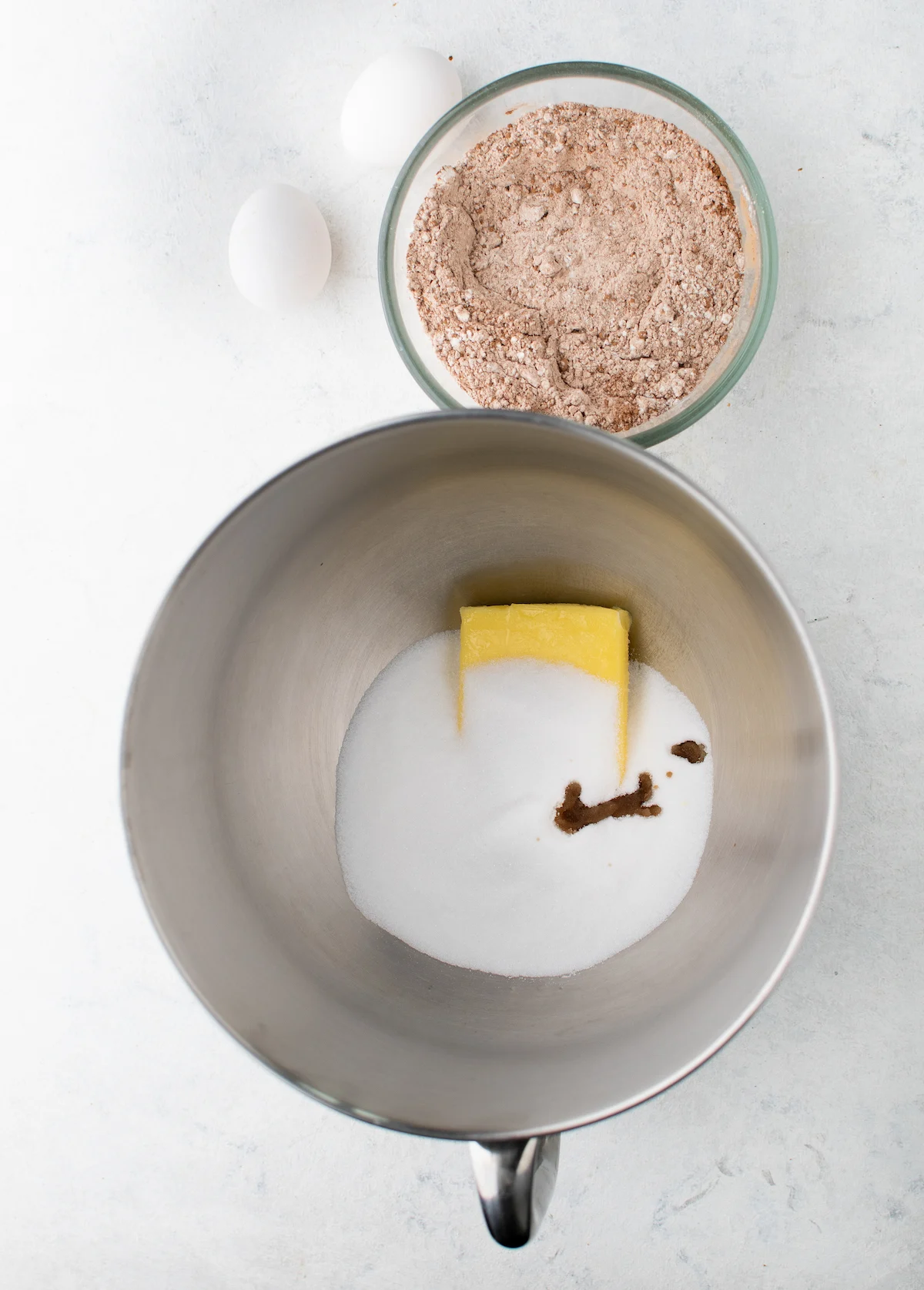 butter and sugar in a mixing bowl with cocoa mixture in another bowl