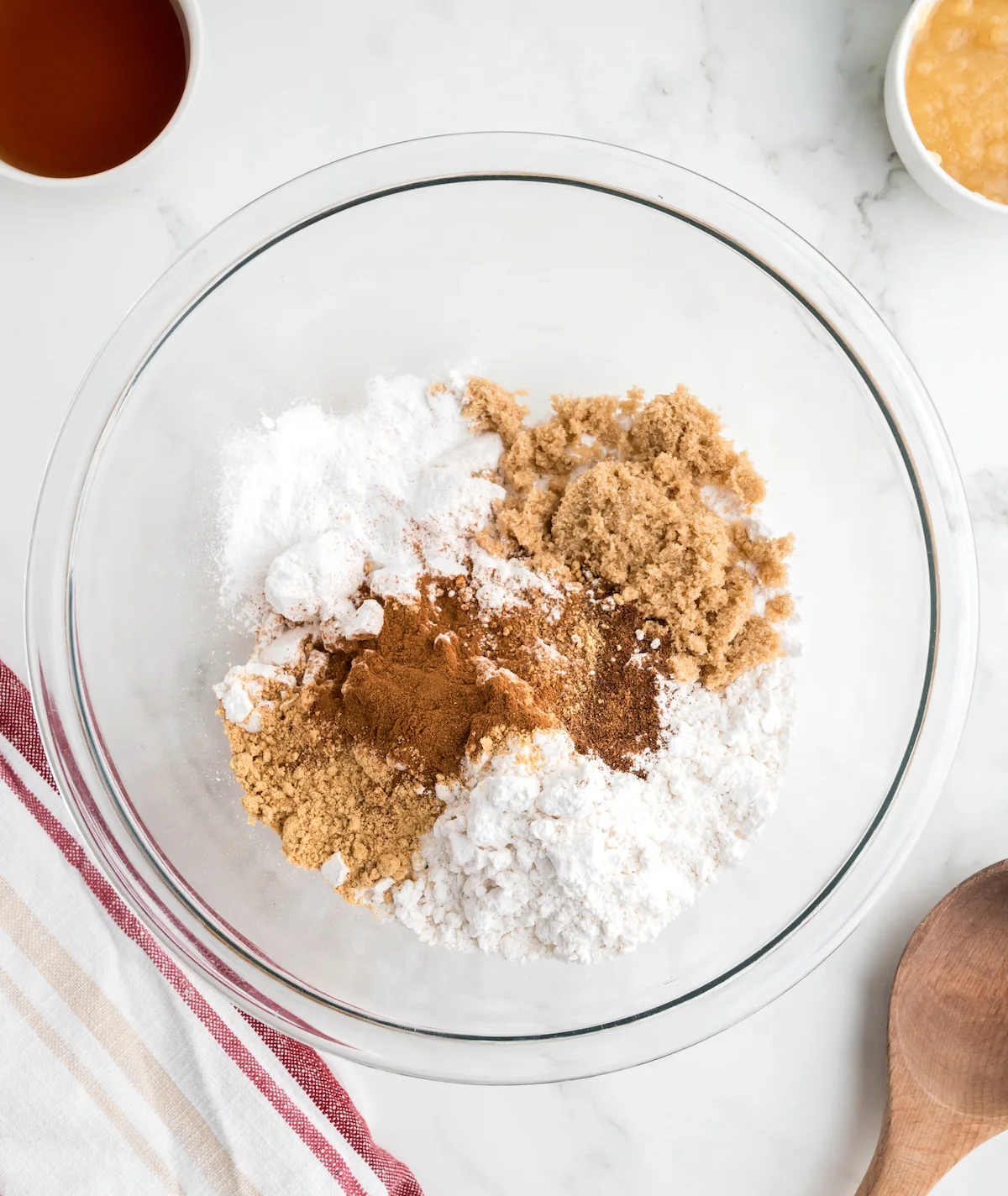 flour, brown sugar, baking powder, baking soda, ginger, cinnamon, cloves, nutmeg, and salt together in a clear glass bowl