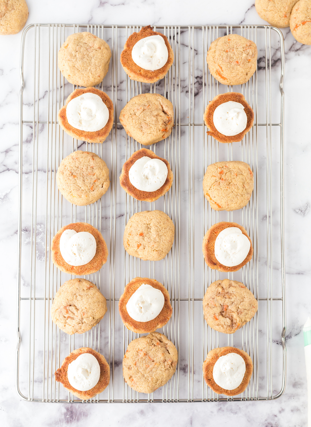 use a piping bag to place the frosting on the carrot cake whoopie pies